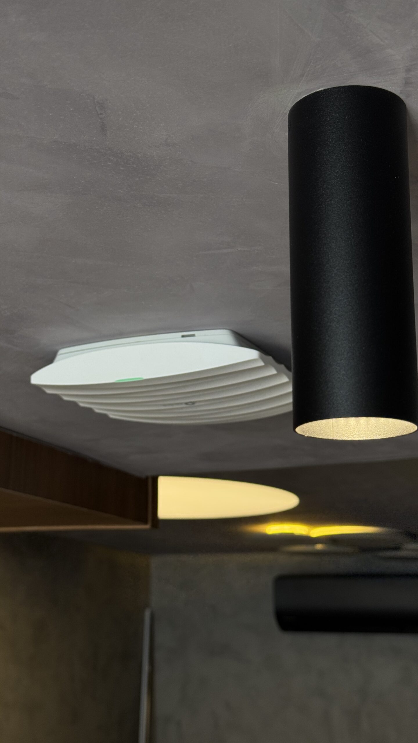 Ponto de acesso Wi-Fi instalado no teto do ambiente.